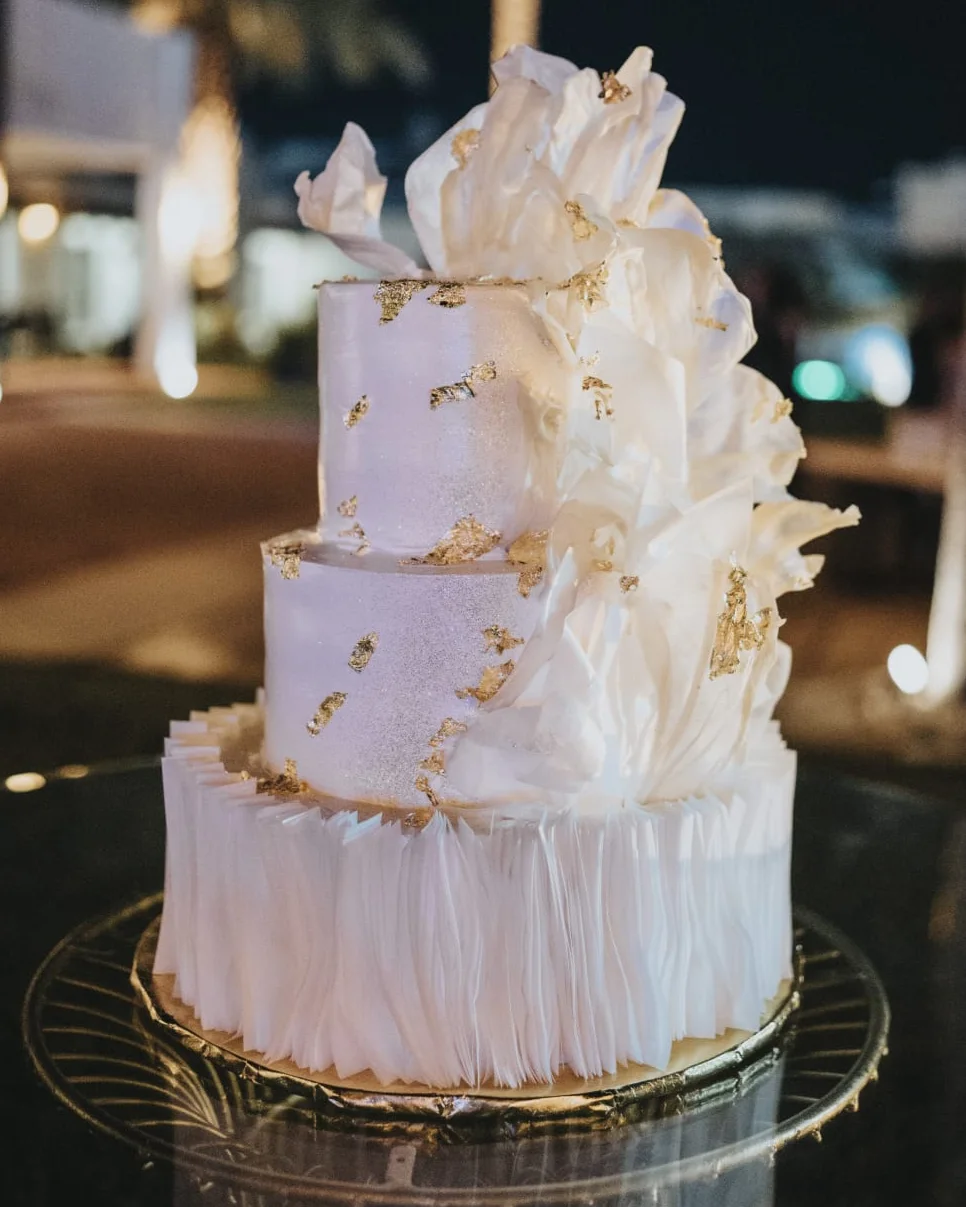 Pastel de bodas de tres pisos con textura nevada y hoja de oro