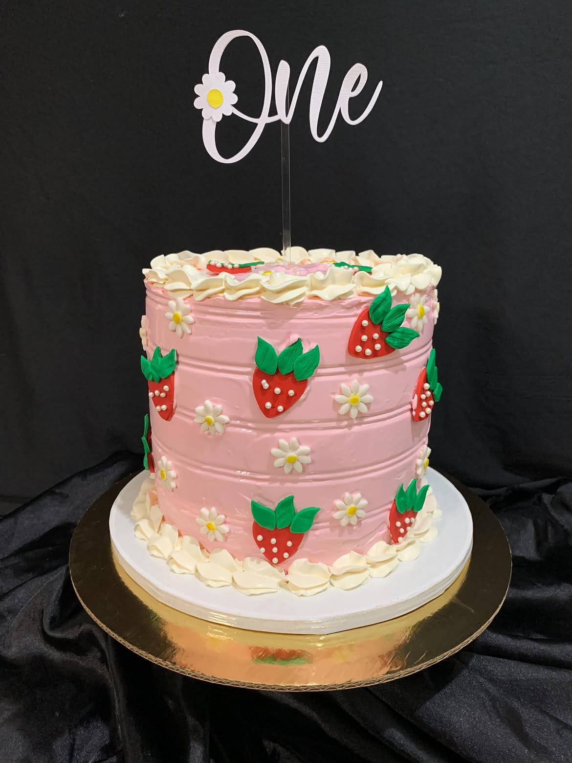 Pastel rosa con fresas y topper "One" para primer año